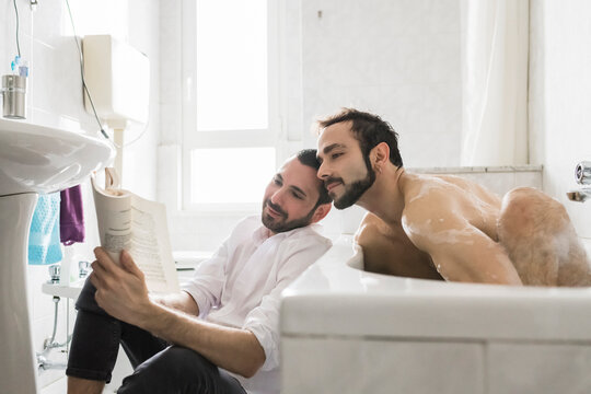 Happy male couple relaxing at home