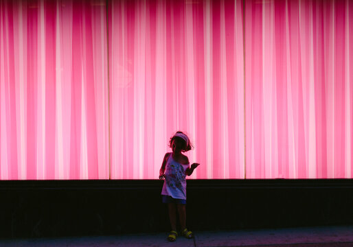 Kid in front of bright pink wall