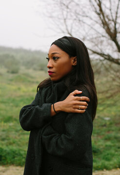 Portrait of black woman with coat outdoors looking to the side