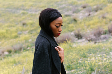 black woman with coat outdoors