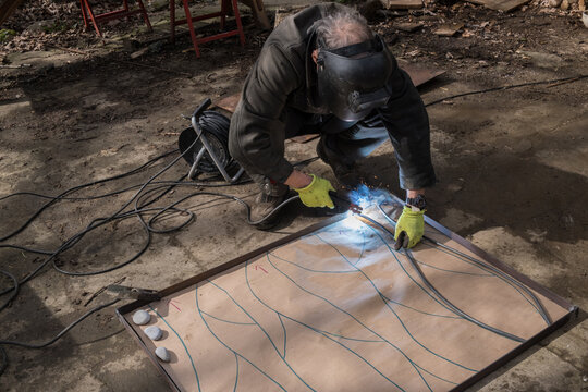 man making iron garden door