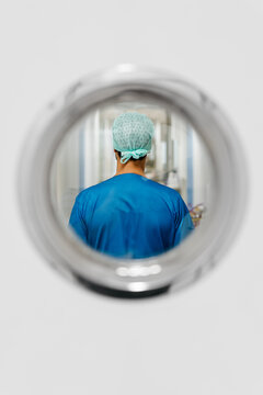 Back view of anonymous nurse through hospital door's window