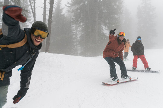 Friends having fun together during a day on the snowboard into the wild