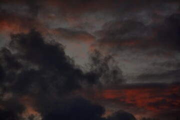 Black wispy clouds and red skies at sunset in Autumn