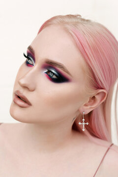 A paleskin girl with gorgeous eyes, pink hair and beautiful fancy make up