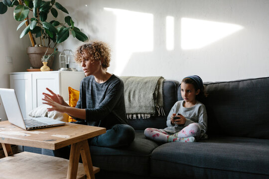 Woman working from home on the couch with kid