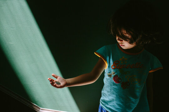 Kid with coin and ray of light