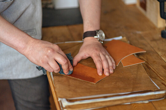 the master waxes a piece of leather