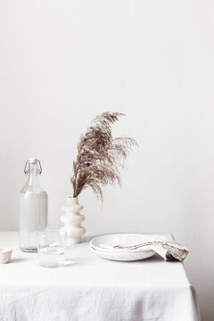 Still life with dried grass, ceramic plates and water bottle