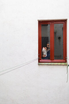 Father and baby looking through the window to the camera