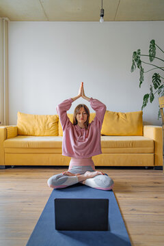 young woman practices yoga in her apartment