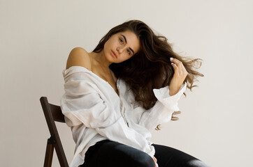 Young woman with long hair sitting on a chair