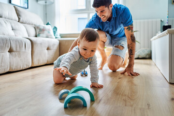 Baby and dad playing at living room's floor