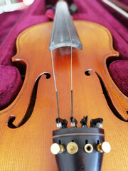 Violin and bow in dark red case. Close up