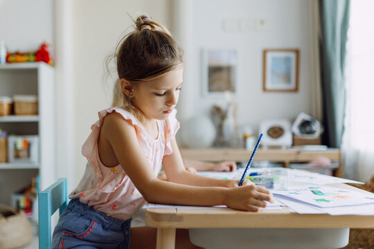 A Girl Coloring At Home