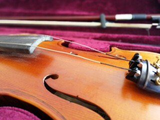 Fototapeta na wymiar Violin and bow in dark red case. Close up