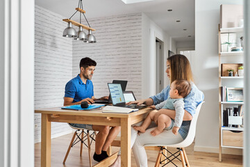 Young parents with baby working at home
