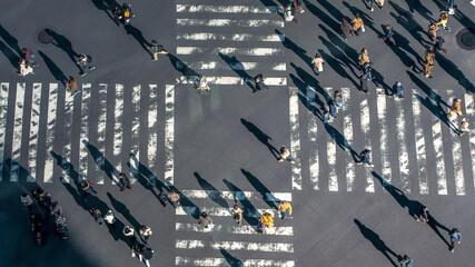 Elevated view over crowd pedestrian crossing in road intersection at day.