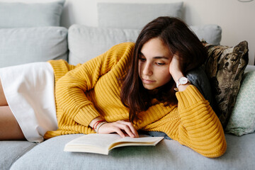 Attractive Young woman reading on the sofa