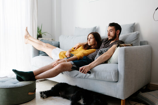 Young couple watching tv at home