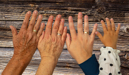 Vier Hände im Alter von jeweils 93 Jahren, 63 Jahren, 33 Jahren und 2 Jahren vor einem Hintergrund...