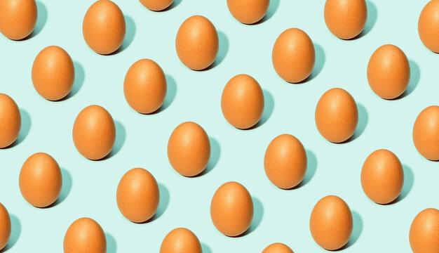 Seamless background of brown eggs placed in rows on white table in studio
