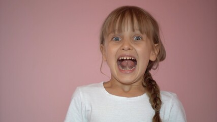 Surprised little girl. Isolate on pink background