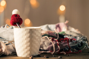 Background with a cup of coffee, a scarf and a small hat. Winter mood.