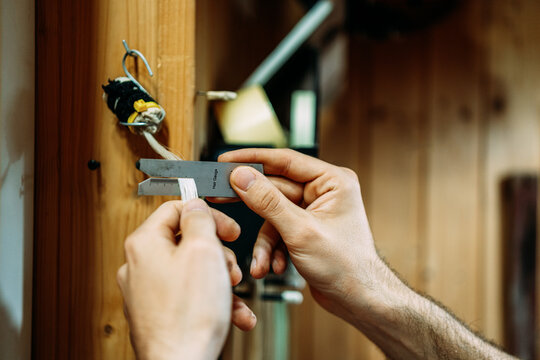 Crop Anonymous Luthier With Bow Hair Gauge Measuring Precise Amount Of Horsehair Needed For Bow Rehairing While Working In Workshop