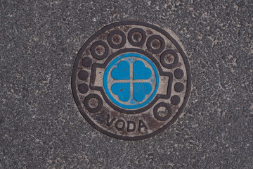 Water line cover on a street with beautiful hearts design and text 