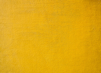 The wooden wall is covered with yellow paint. Traces of the effects of atmospheric precipitation are visible.