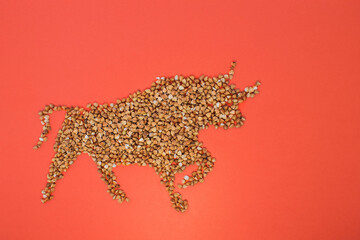 New year's symbol in the form of a bull made of buckwheat on a red background. New year 2021