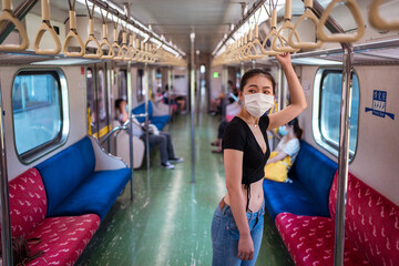 Side view of ethnic female wearing protective mask traveling by train during coronavirus outbreak