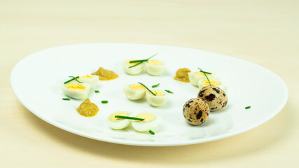 boiled quail eggs with mustard and chives on a plate