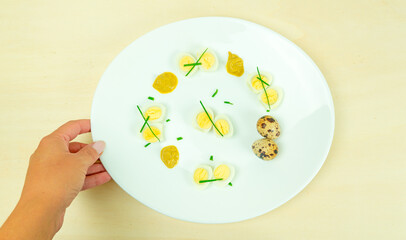boiled quail eggs with mustard and chives on a plate
