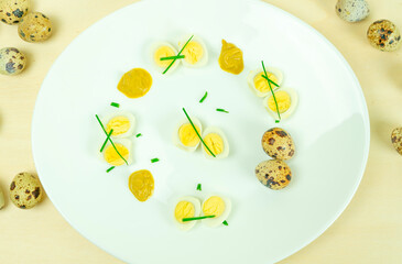 boiled quail eggs with mustard and chives on a plate