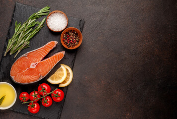 Raw fish salmon steak with lemon and rosemary on a stone background  with copy space	