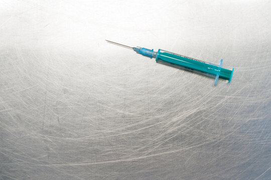 Top view of clean syringe placed on metal table