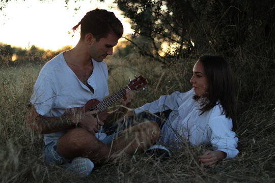 Pareja con ukelele en el campo