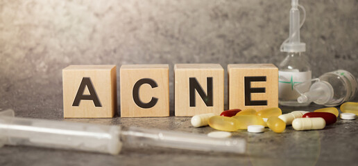 ACNE as a text with letters, corona virus pandemic with word cubes on a dark grey background with space for text.