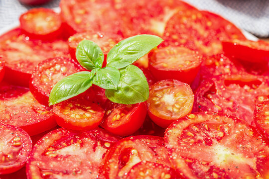 Close up of Tomato salad and basil leaves on plate. Mediterranean food