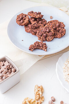 Freshly baked oatmeal and banana cookies on a plate, one is bitten. Studio shot