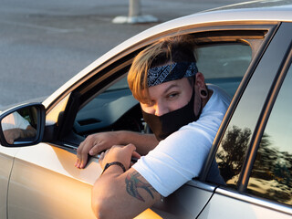 Naklejka premium Hombre joven con mascarilla sacando la cabeza por fuera de la mascarilla