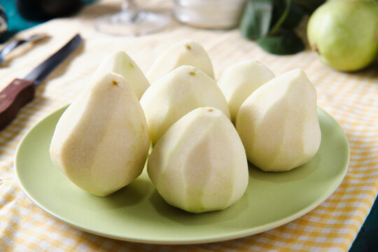 High angle of ripe pears on plate prepared for cooking dessert