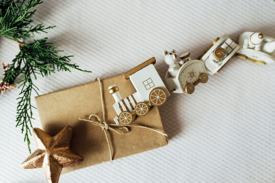White toy train and animals figurines placed with present wrapped in craft paper on table arranged for Christmas celebration