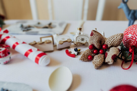White toy train and animals figurines placed with present wrapped in craft paper on table arranged for Christmas celebration