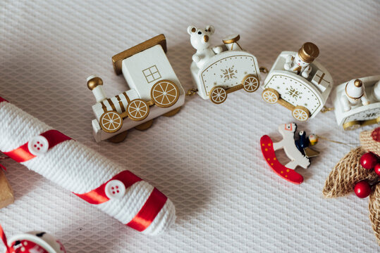 White toy train and animals figurines placed with present wrapped in craft paper on table arranged for Christmas celebration