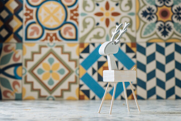 Closeup of handmade miniature wooden deer figurine painted in white color for Christmas decor