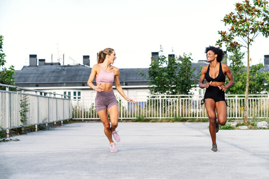 Smiling Young Women Running On Road