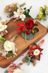 colorful groom boutonnieres together on the piece of wood